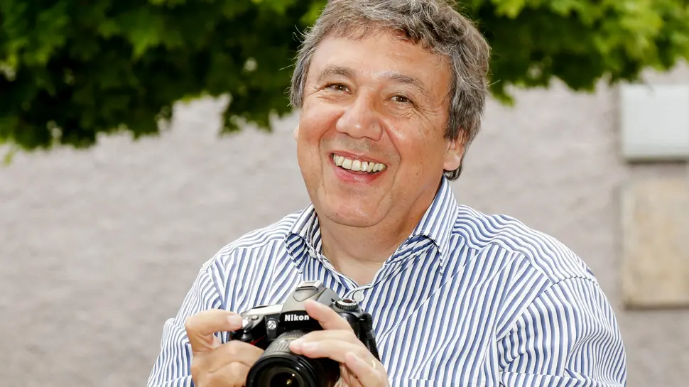 Portraitfoto von Josef Biederman, eine Kamera in den Händen